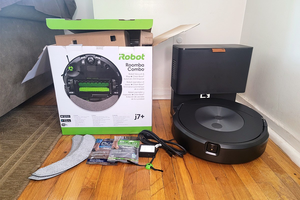 iRobot Roomba j7+ Combo next to product box on wood floor