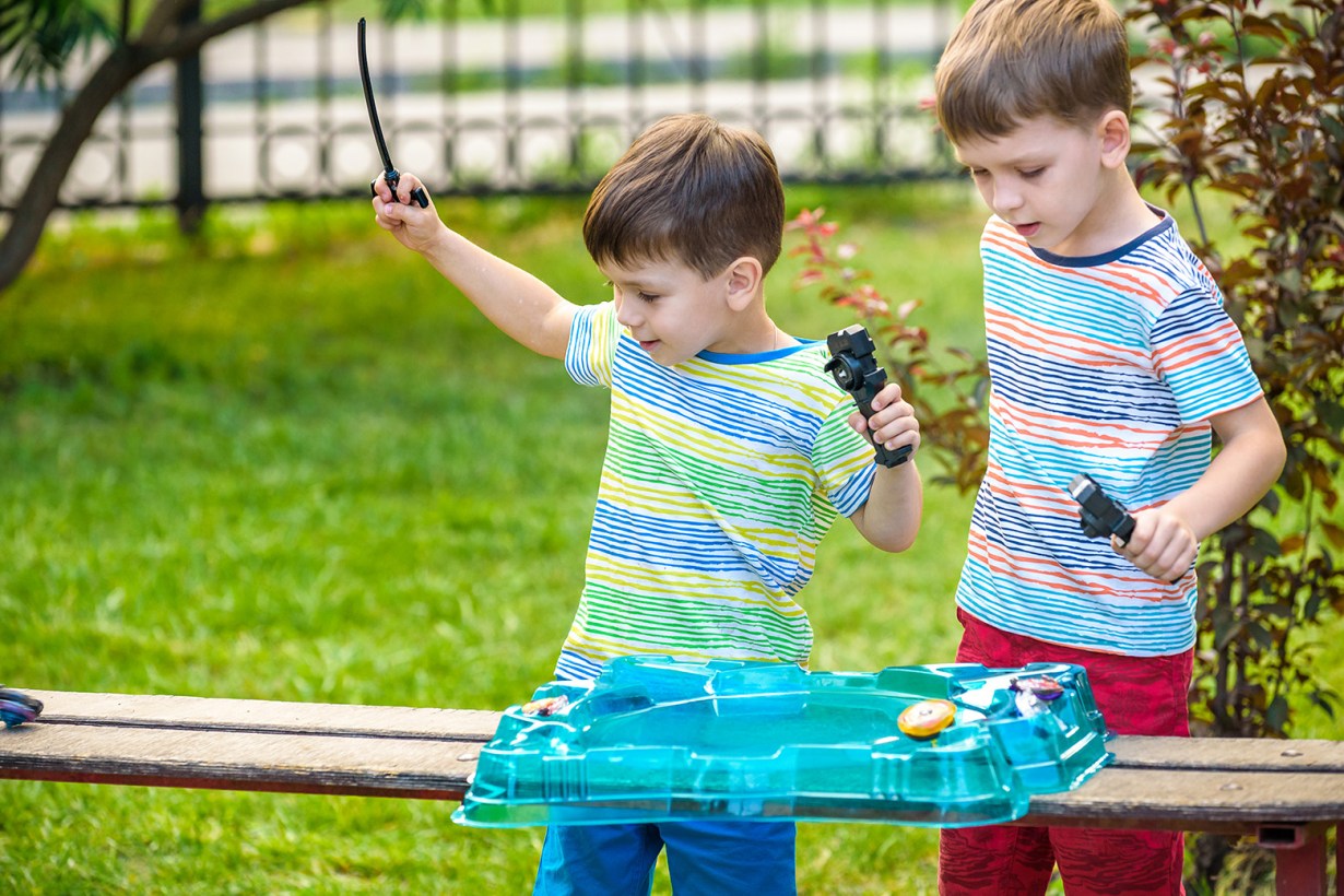 two kids playing Beyblade