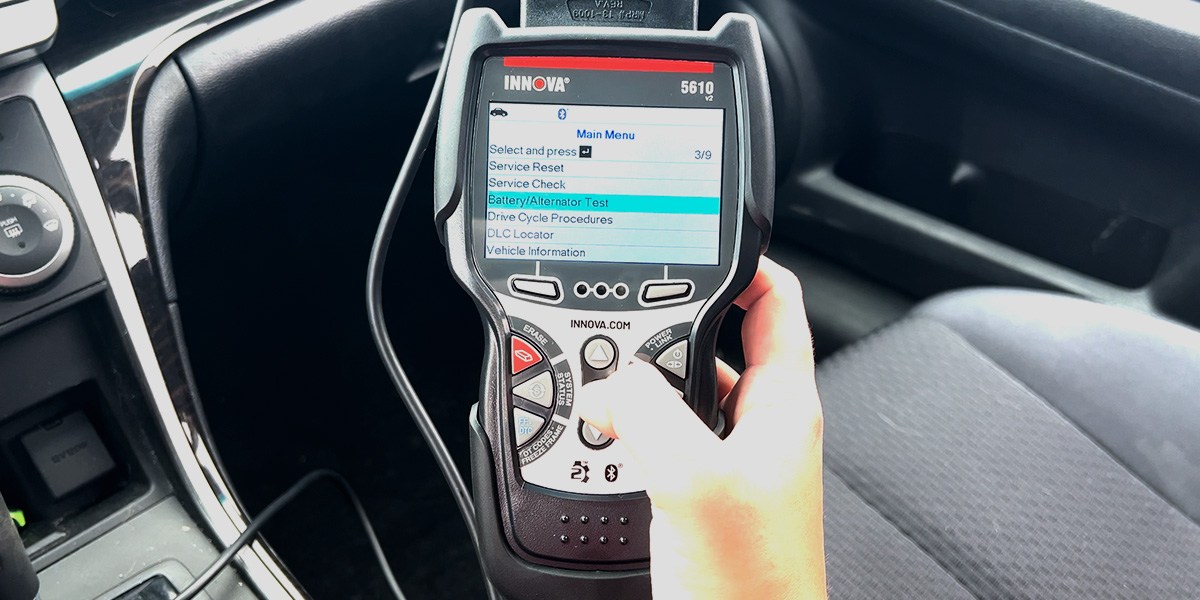 Person holding Innova Bidirectional Scan Tool inside car Person holding Innova Bidirectional Scan Tool inside car