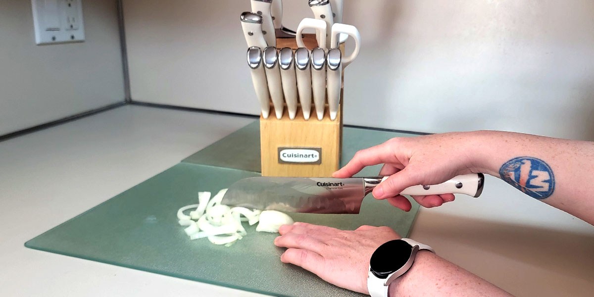 Hand using knife to cut onion Hand using knife to cut onion