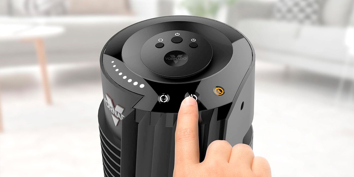 Person's finger pressing button on black Vornado OSC84 Tower Fan Person's finger pressing button on black Vornado OSC84 Tower Fan