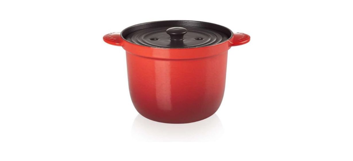 a reddish-orange pot with a black lid on top and a handle on each side