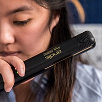 a woman using a hair straightener