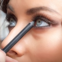 a woman putting on makeup