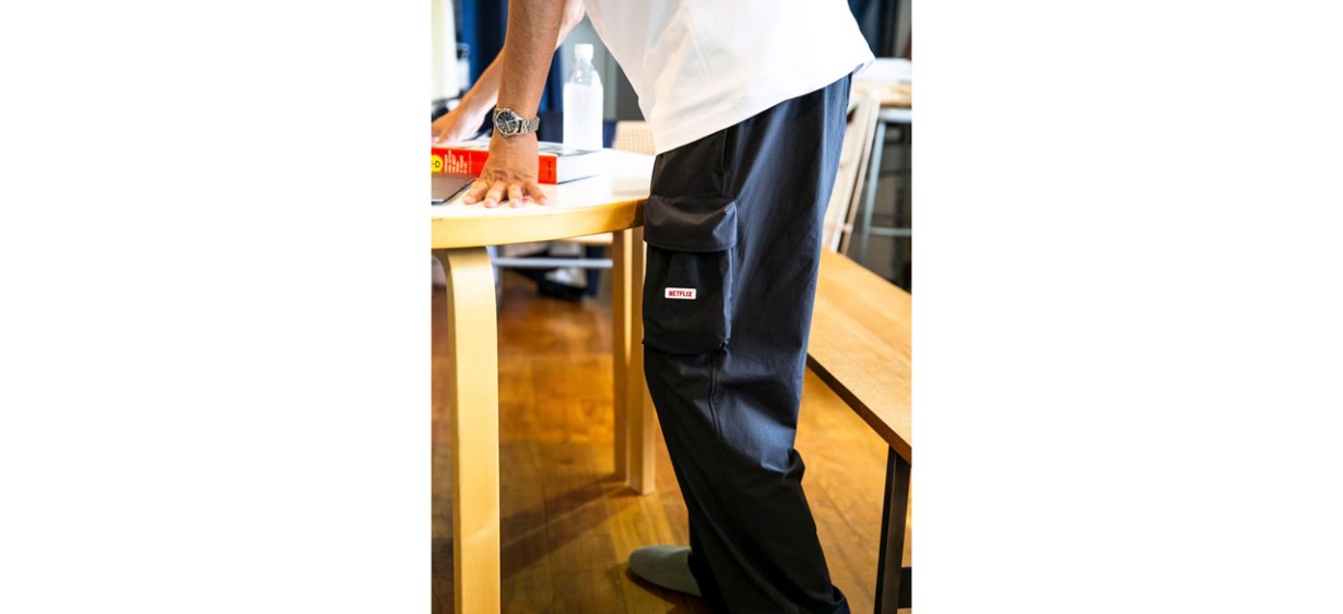 Person wearing Netflix Nylon Track Pants leaning on table