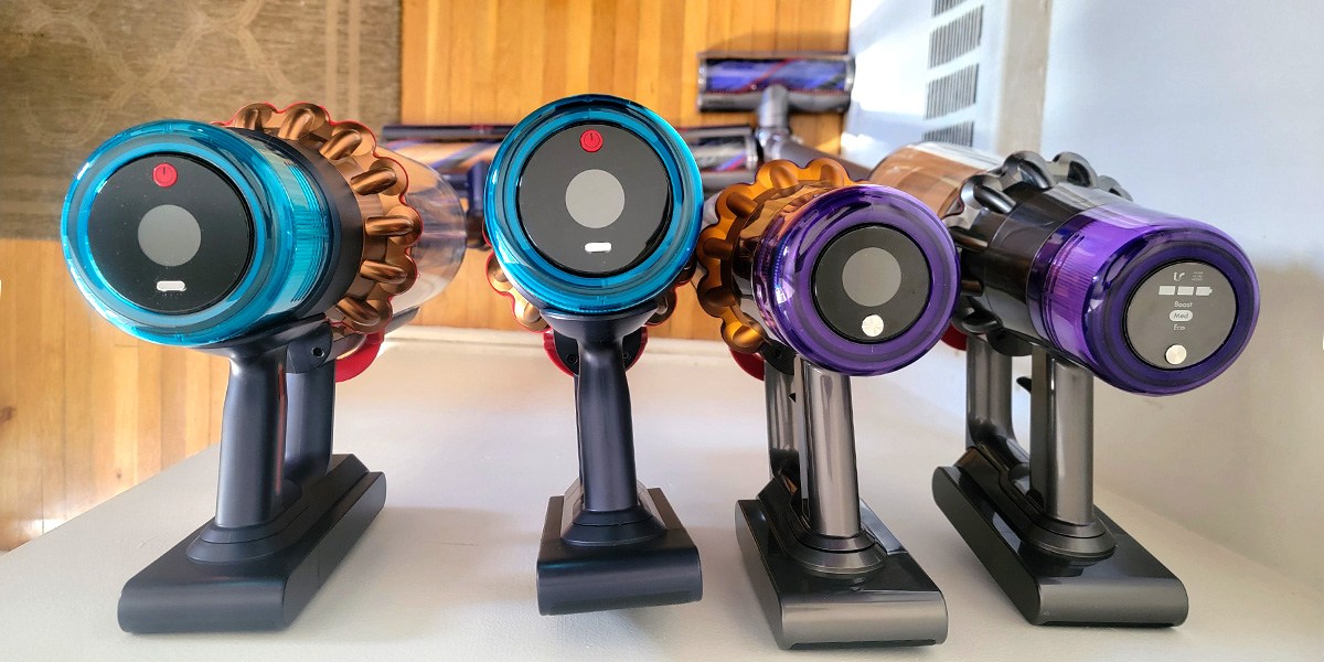 Top view of four stick vacuums leaning against wall