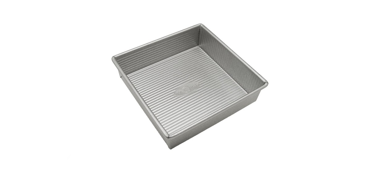 A metal square cake pan with small horizontal grooves on the inside